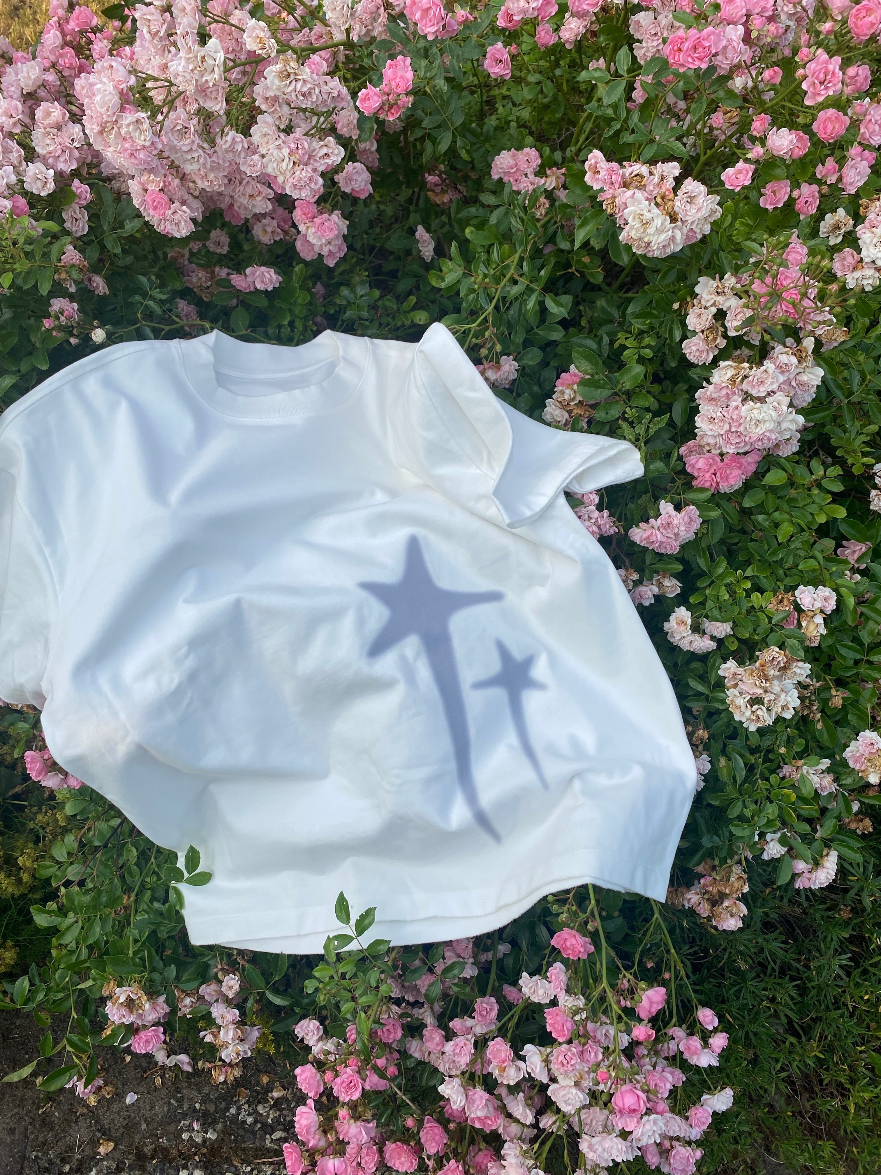 White shirt star design on a bed of pink flowers